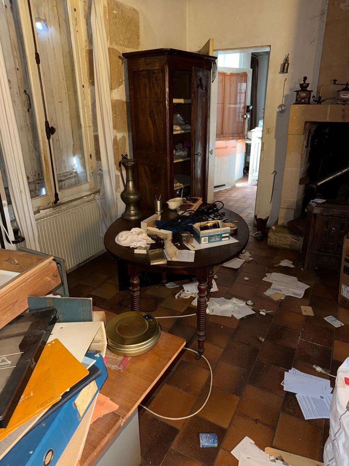 Pièce de maison de campagne encombrée de meubles et papiers avant débarras