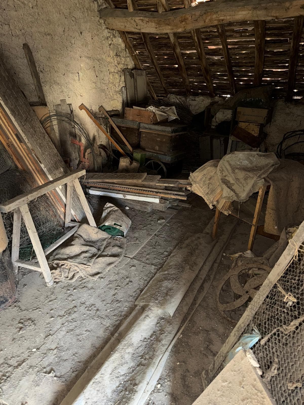 Pièce vidée avec tomettes et cheminée en marbre visibles après débarras